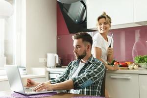 Funny image of guy with a laptop and her crazy girlfriend with a knife photo