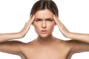 Woman with a headache on white background photo