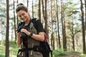 excursionista usando una cámara sin espejo moderna en un bosque verde foto