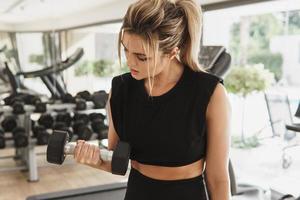 mujer atlética haciendo ejercicio con pesas en el gimnasio foto