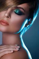 Sexy model in stylish image with sleek hair covering one eye and beautiful green eyeshadows on another photo