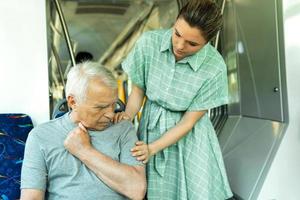 Young woman and senior man with a coronary disease having heart attack symptoms in public transport
