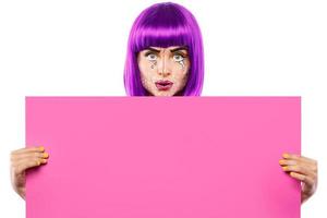Model in creative image with pop art makeup is holding pink blank board photo