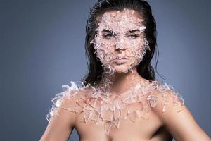 rostro femenino cubierto con muchos pequeños trozos de vidrio o hielo foto