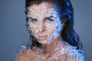 Female face covered with a lot small pieces of glass or ice photo