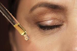 Female eye and dropper with rejuvenating serum photo