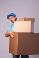 repartidor feliz durante el trabajo con paquetes en cajas de cartón foto