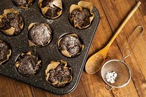 Baking tin with a tasty chocolate muffins photo