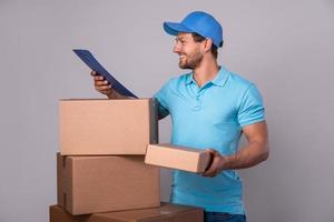 Happy delivery man during work with a packages in a cardboard boxes photo