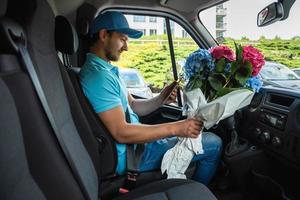 Courier inside the white van during flowers delivery photo