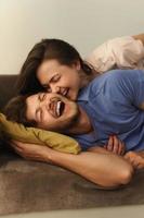 Young and happy couple lying on a sofa photo