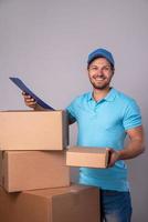 repartidor feliz durante el trabajo con paquetes en cajas de cartón foto