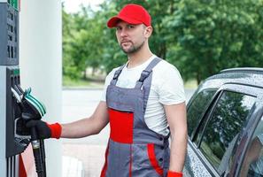 Filling station attendant filling tank of clients car photo