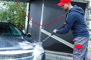 Car wash worker is washing client's car photo