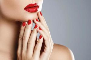 Close-up of female mouth and nails with red manicure and lipstick. photo