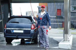 Car wash worker is washing client's car photo