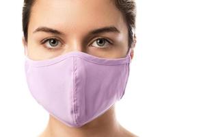 Woman wearing purple prevention mask on white background photo