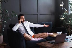 Lazy businessman without pants working from home photo