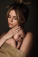 Beautiful mother and her little baby are wrapped in sackcloth photo
