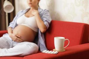 Young pregnant woman with a sore throat photo