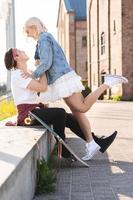 Teenage couple with a longboard during their date in a city photo