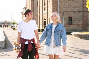 Teenage couple with a longboard during their date in a city photo