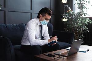 Businessman wearing prevention mask during his work at home photo