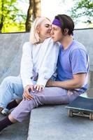 Stylish teenager couple in love during their date in a skate park photo