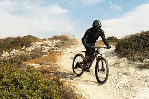 Rider fully equipped with protective gear during downhill ride on his bicycle photo