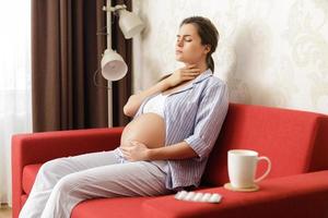 Young pregnant woman with a sore throat photo
