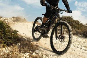 Rider fully equipped with protective gear during downhill ride on his bicycle photo