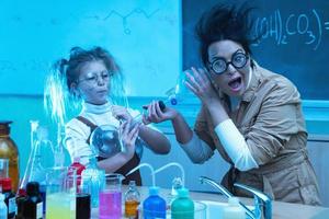 profesor y niña durante la lección de química mezclando productos químicos en un laboratorio foto