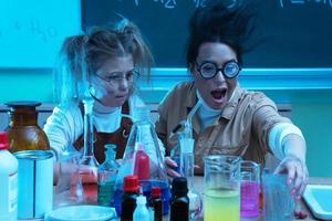 profesor y niña durante la lección de química mezclando productos químicos en un laboratorio foto