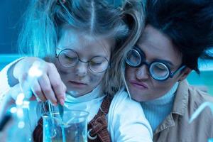 profesor y niña durante la lección de química mezclando productos químicos en un laboratorio foto