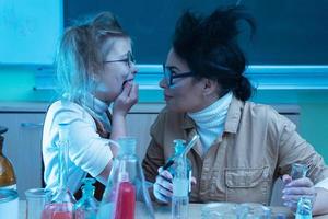 profesor y niña durante la lección de química mezclando productos químicos en un laboratorio foto