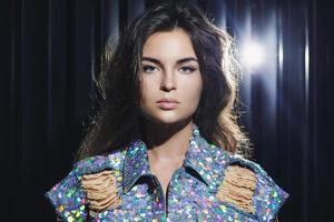 Sexy woman wearing stylish shimmering jacket covered with a lot of sequins photo