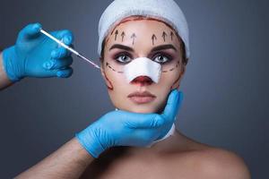 Woman wrapped with bandages and scars is prepared for another one operation. photo