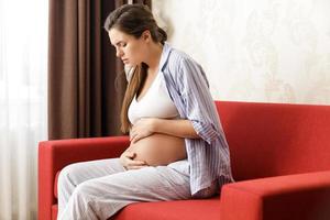 Pregnant woman at home. Different health problems during pregnancy. photo