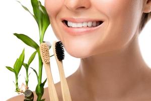 Female mouth with white teeth and bamboo toothbrush photo