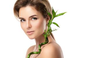 Young beautiful woman with a green bamboo branch photo