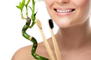 Female mouth with white teeth and bamboo toothbrush photo