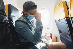 Man wearing prevention mask during a flight inside an airplane photo