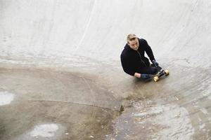 Young handicapped guy with a longboard in a skatepark photo