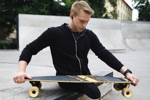 Motivated handicapped guy with a longboard in the skatepark photo