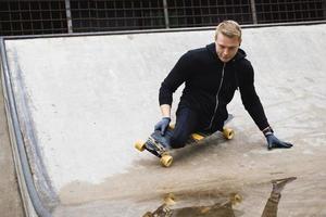 Motivated handicapped guy with a longboard in the skatepark photo