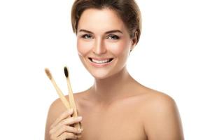 Young happy woman with eco-friendly bamboo toothbrushes photo