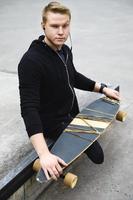 Young handicapped guy with a longboard in a skatepark photo