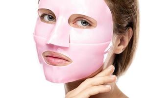 Young beautiful woman with rubber facial mask on her face photo