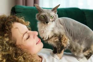 Young woman and her cute cat lying  on the sofa photo