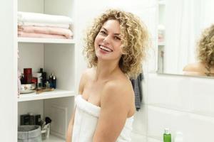 mujer joven y hermosa con el pelo rizado después de una ducha foto